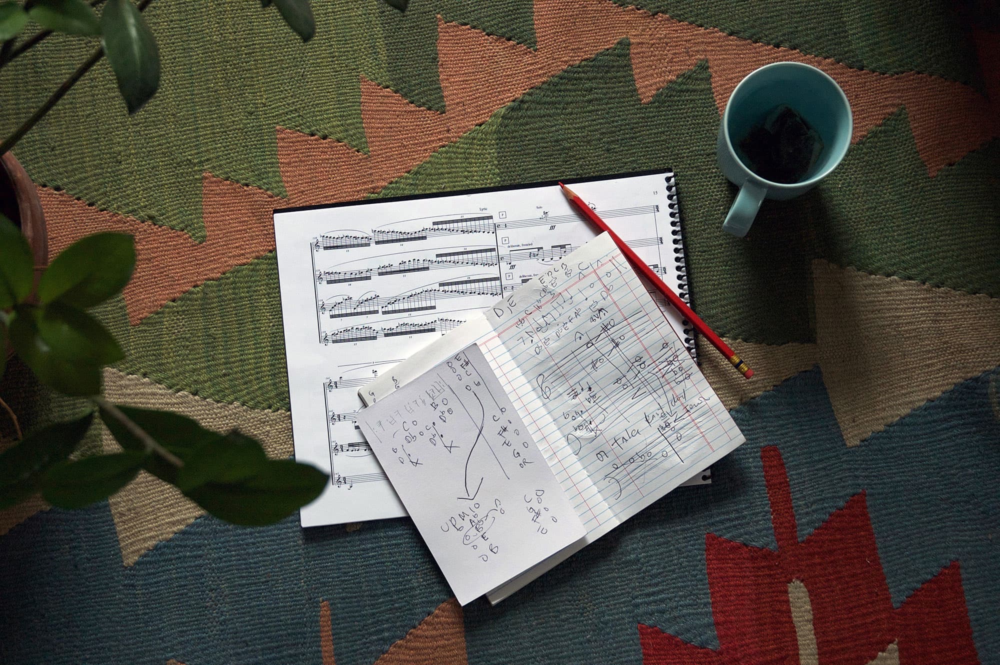 aerial view of musical score, pencil, and notebook